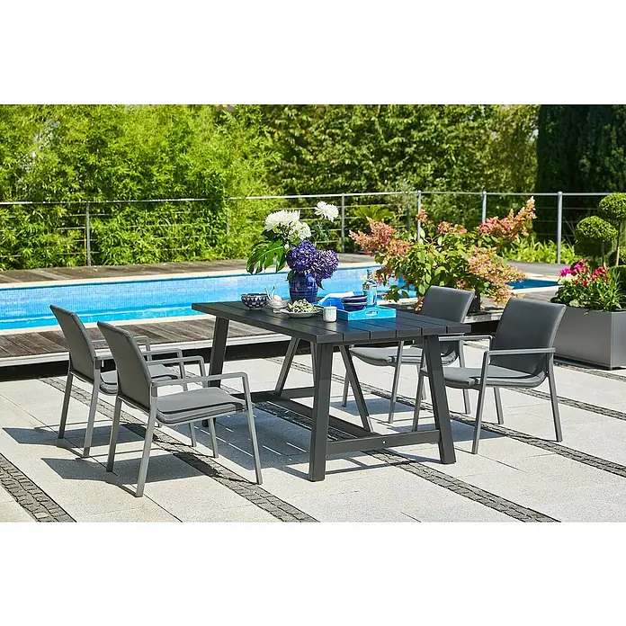 Sunfun Lumar Loungesessel - L x B x H: 64 x 78,5 x 67 cm, Aluminium, Textil, Night-Grey - Dunkler Gartentisch mit Stühlen auf einer Terrasse neben einem Pool. Dekoriert mit Blumen und Geschirr.