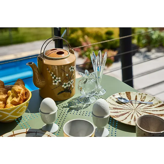 Balkonmöbel-Set Jordan - 3 -tlg., Grün, Klappbar - Nahaufnahme eines gedeckten Frühstückstisches mit einer Teekanne, Croissants, Eiern und dekorativen Glaswaren im Freien.