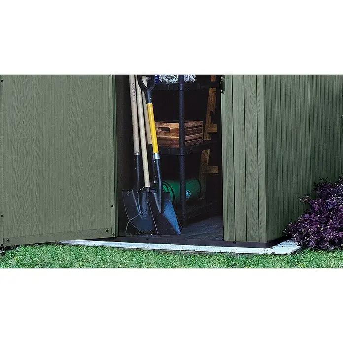 Keter Gartenhaus Darwin 4x4 - Außenmaß inkl. Dachüberstand (B x T): 125,8 x 117 cm, Kunststoff, Grün, 1,5 m² - Ein grüner Gartenschrank mit geöffneter Tür, der Gartengeräte wie Spaten und eine Holzkiste zeigt, bietet praktische Aufbewahrung.