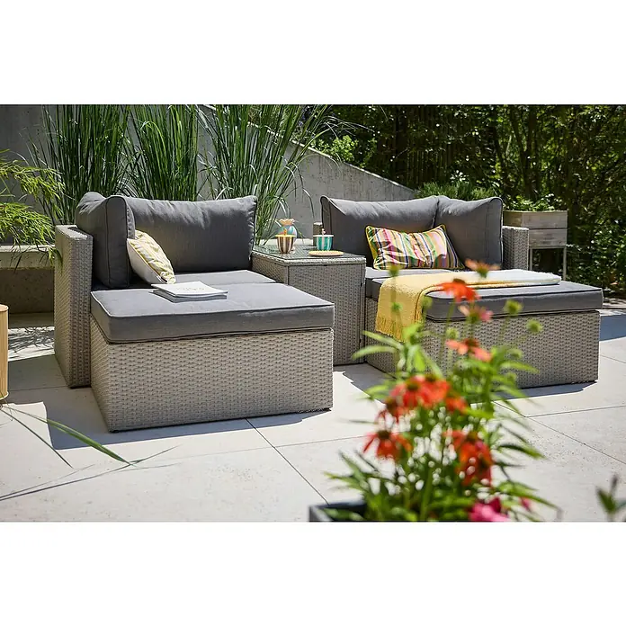 Loungemöbel-Set - 5 -tlg., Aluminium, Polyrattan, Anthrazit - Ein graues Gartenmöbelset aus Rattan mit Kissen und Beistelltisch steht auf einer Terrasse. Es ist einladend und perfekt zum Entspannen im Freien.