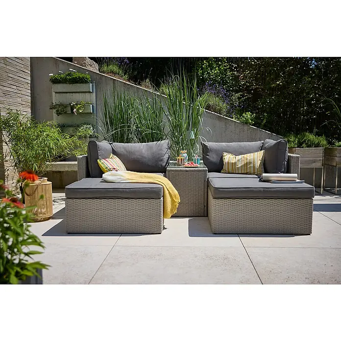 Loungemöbel-Set - 5 -tlg., Aluminium, Polyrattan, Anthrazit - Eine graue Rattan-Gartenlounge mit bequemen Kissen und einem kleinen Tisch, ideal für entspannte Stunden im Freien. Die Lounge lädt zum Verweilen ein.