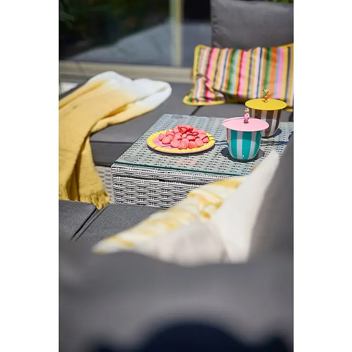 Loungemöbel-Set - 5 -tlg., Aluminium, Polyrattan, Anthrazit - Ein Gartentisch mit Snacks, Dekoartikeln und einem gelben Überwurf. Die Dekoartikel verleihen der Szene einen Hauch von Farbe und Verspieltheit.