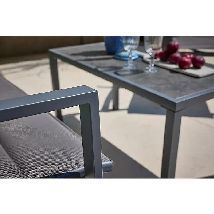 Loungemöbel-Set - 4 -tlg., Metall/Textil, Schwarz/Grau - Nahaufnahme eines modernen Gartenmöbelsets mit einem grauen Tisch und einem Sessel mit grauem Stoffbezug. Ideal für entspannte Stunden im Freien.