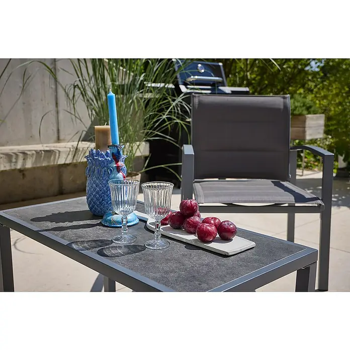 Loungemöbel-Set - 4 -tlg., Metall/Textil, Schwarz/Grau - Nahaufnahme eines Tisches mit Gläsern, Kerzen und Pflaumen, im Hintergrund ein Grill und ein Stuhl.