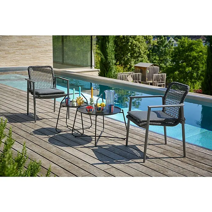 Sunfun Melina Garten-Beistelltisch rund - Ø x H: 80 x 60,5 cm, Stahl, Night-Grey - Zwei graue Rattansessel mit Armlehnen und Sitzkissen stehen an einem Pool auf einer Terrasse mit zwei kleinen Tischen.