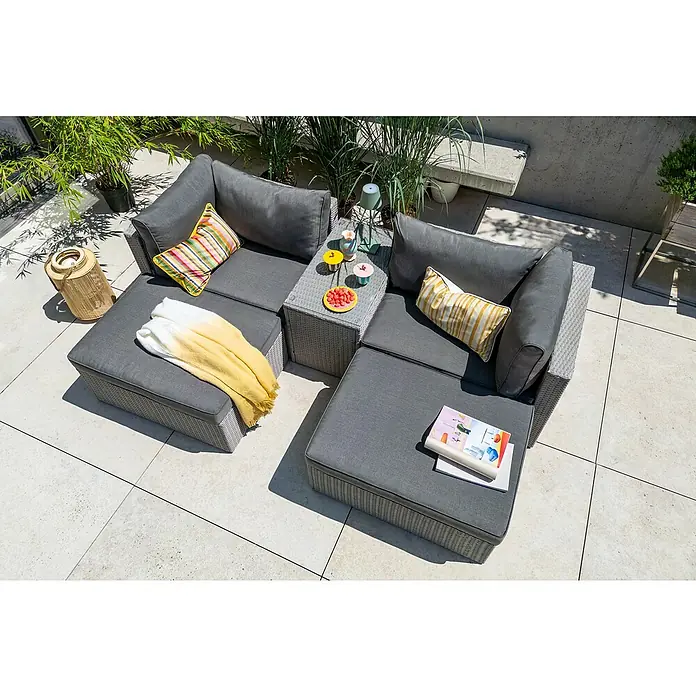 Loungemöbel-Set - 5 -tlg., Aluminium, Polyrattan, Anthrazit - Graues modulares Gartensofa mit Kissen, Decke, Tisch und Dekoration auf einer gefliesten Terrasse im Freien.