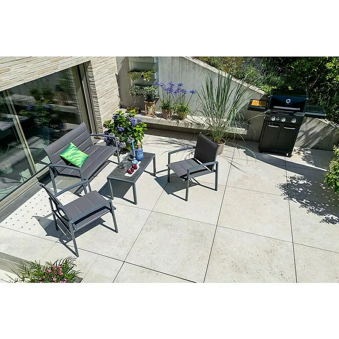 Loungemöbel-Set - 4 -tlg., Metall/Textil, Schwarz/Grau - Ein Outdoor-Essbereich mit grauen Gartenmöbeln, bestehend aus einem Tisch, Stühlen und einer Bank mit Kissen, sowie einem Grill.
