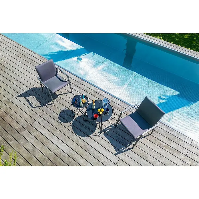 Sunfun Melina Garten-Beistelltisch rund - Ø x H: 80 x 60,5 cm, Stahl, Night-Grey - Zwei graue Sessel und ein kleiner Tisch mit Getränken stehen auf einer Holzterrasse neben einem Pool. Perfekt zum Entspannen.