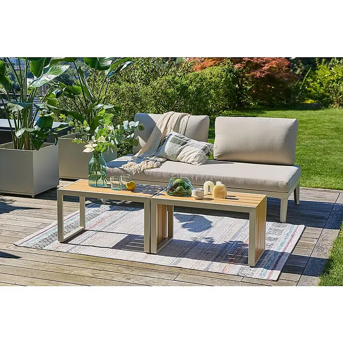 Sunfun Solo Loungemöbel-Set Solo Rope - 3 -tlg., Aluminium/Kunststoff/Olefin, Light-Greige - Einladende Gartenszene mit einem beigen Lounge-Sofa, stilvollen Couchtischen und üppigen Pflanzen für eine entspannte Atmosphäre im Freien.