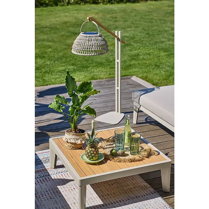 Sunfun Solo Garten-Couchtisch - L x B x H: 72 x 72 x 26 cm, Aluminium, Light-Greige - Nahaufnahme eines Tisches im Freien mit tropischen Elementen und einer stilvollen, freistehenden Lampe für eine entspannte Atmosphäre.
