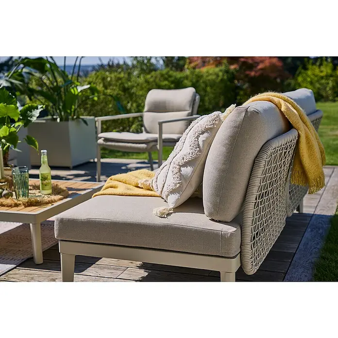 Sunfun Solo Rope Sofá de conjunto - An x Pr x Al: 167,5 x 86,5 x 66 cm - Primer plano de una lujosa tumbona de exterior con cojines beige y un plaid amarillo, perfecta para horas de relax en el jardín.