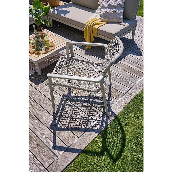 Sunfun Solo Rope Loungesessel - B x T x H: 69,5 x 74 x 72 cm, Aluminium, Kunststoff, Light-Greige - Ein stilvoller Rattansessel mit Armlehnen steht auf einer Holzterrasse, perfekt für entspannte Stunden im Freien.