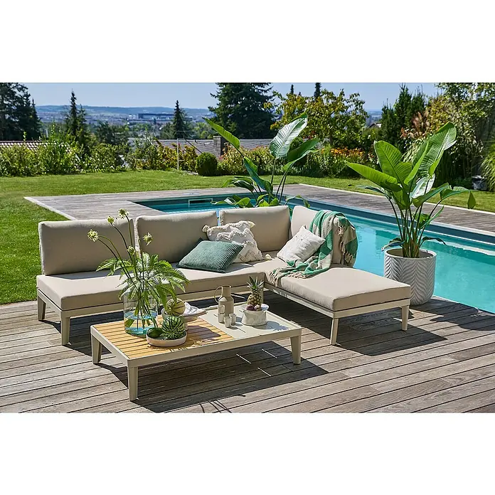 Sunfun Solo Garten-Couchtisch - L x B x H: 120 x 72 x 26 cm, Aluminium, abnehmbares Tablett, Light-Greige - Einladende Gartenlounge mit beigen Polstern und dekorativen Kissen neben einem erfrischenden Pool auf einer sonnigen Holzterrasse.
