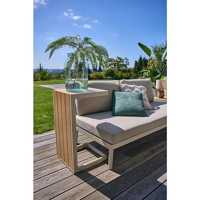 Sunfun Solo Garten-Beistelltisch - L x B x H: 73 x 38,5 x 41 cm, Aluminium, Light-Greige - Nahaufnahme eines stilvollen Outdoor-Sofas mit Beistelltisch, dekoriert mit Kissen und einer Vase mit Pflanzen. Die Holzterrasse ergänzt das Ambiente.