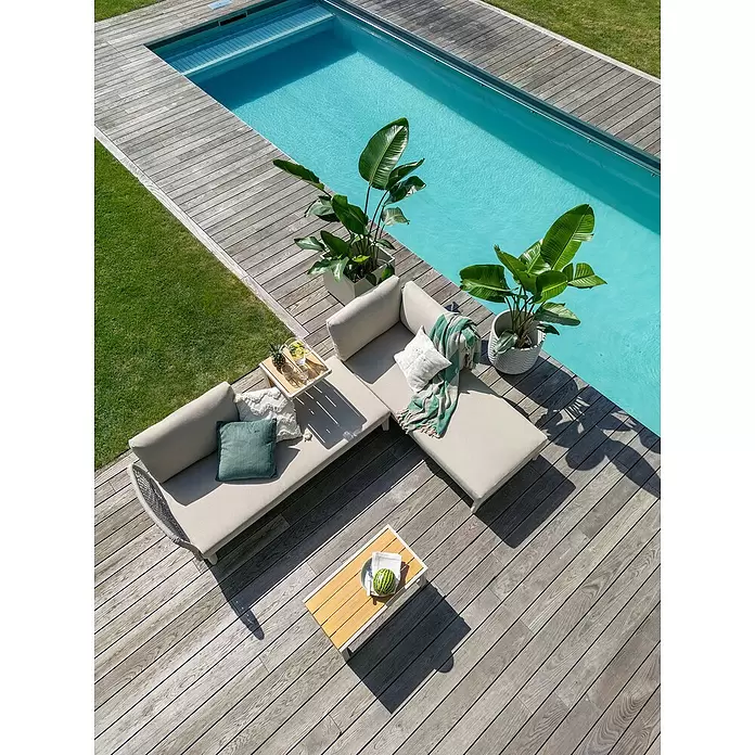 Macetero redondo Birmingham - Dimensiones externas (Ø x Al): 40 x 40 cm, Material compuesto, Crema - Un elegante conjunto de salón exterior claro con cojines y mesas auxiliares está dispuesto en una terraza de madera junto a una piscina.