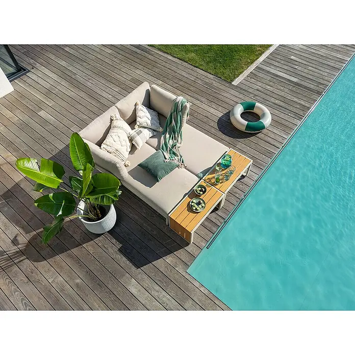 Sunfun Solo Conjunto de muebles chaise lounge + mesa auxiliar - 4 pzs., Gris claro - Un cómodo conjunto de sala de estar al aire libre con una mesa y decoraciones se encuentra en una terraza de madera.