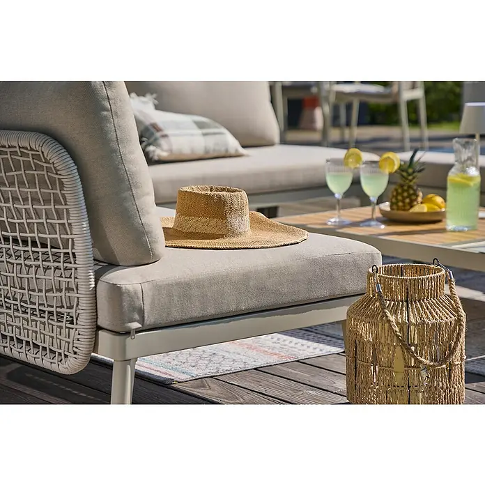 Sunfun Solo Rope Loungesofa - L x B x H: 167,5 x 86,5 x 66 cm, Aluminium, Light-Greige - Detailaufnahme eines Gartensets mit einem Strohhut auf einem Sessel, Getränken und einer Laterne, die eine entspannte Atmosphäre vermitteln.