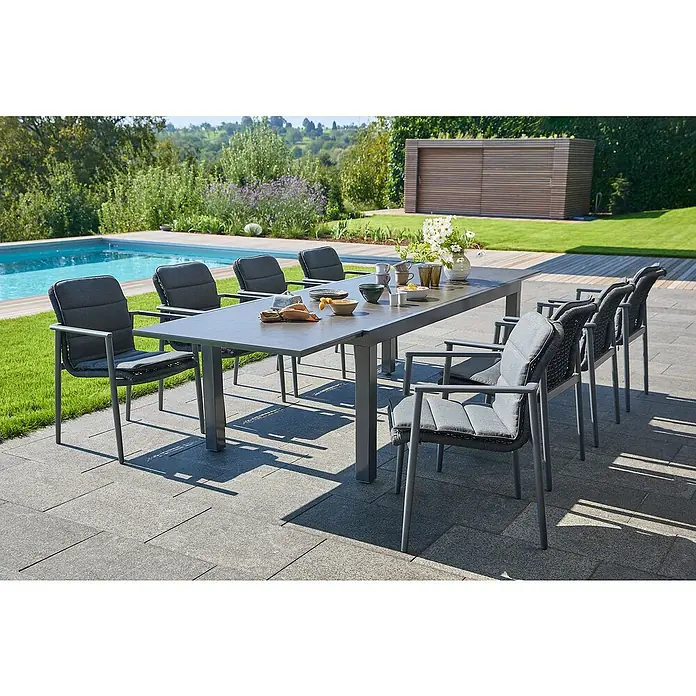 Sunfun Gartenmöbel-Set Maja/Solo - 17 -tlg., Aluminium, Polyester, Night-Grey, Ausziehbar - Ein grauer Gartentisch mit passenden Stühlen auf einer Terrasse neben einem Pool. Das Set ist elegant und modern gestaltet.