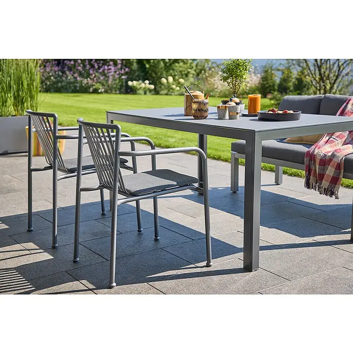 Sunfun Gartenmöbel-Set Maja/Sarah - 4 -tlg., Aluminium, Stahl, Sicherheitsglas, Night-Grey - Ein grauer Esstisch mit zwei Stühlen und einer Bank im Garten mit verschiedenen Dekorationen.