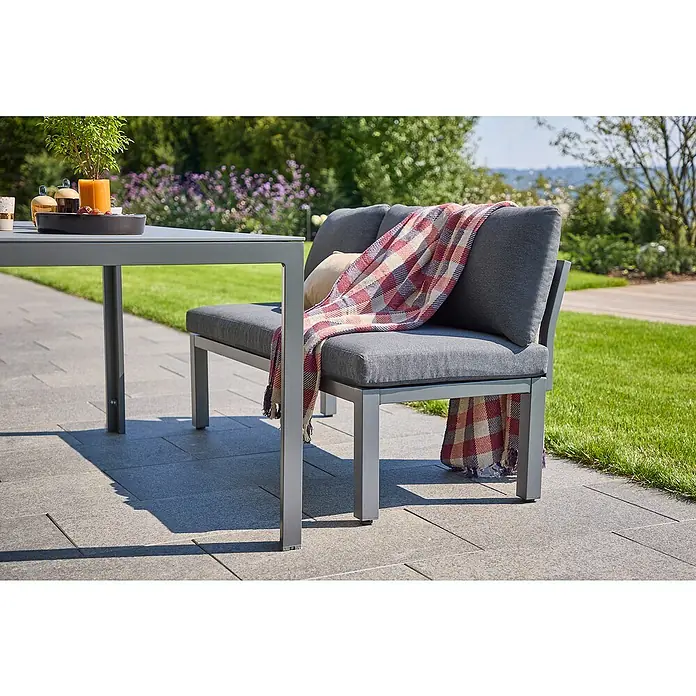 Sunfun Maja Loungesofa - B x T x H: 140 x 67 x 65 cm, Aluminium, Night-Grey - Graue Gartenbank mit karierter Decke und grauem Tisch auf einer Terrasse.