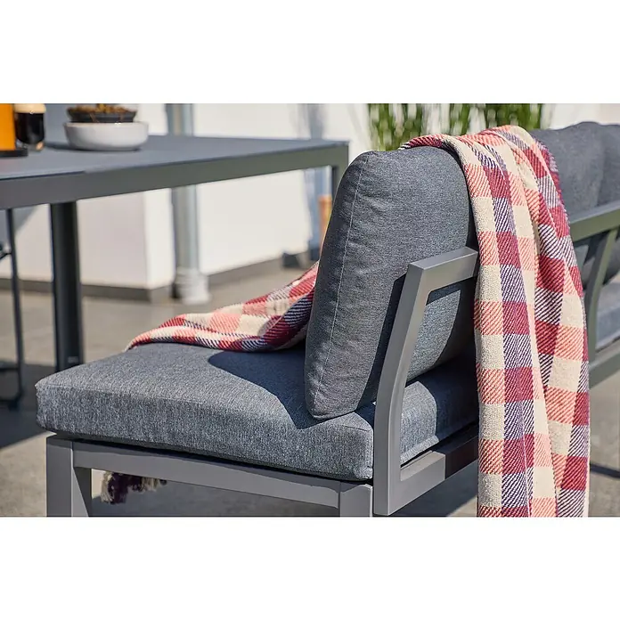 Sunfun Maja Loungesofa - B x T x H: 140 x 67 x 65 cm, Aluminium, Night-Grey - Nahaufnahme eines grauen Gartensofas mit einer karierten Decke, die lässig über die Rückenlehne drapiert ist, für entspannte Stunden im Freien.