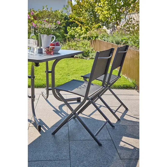 Sunfun Gartenmöbel-Set Boulevard/Maja - 5 -tlg., Anthrazit - Ein Gartentisch-Set mit zwei Klappstühlen auf einer Terrasse, ideal für entspannte Stunden im Freien.