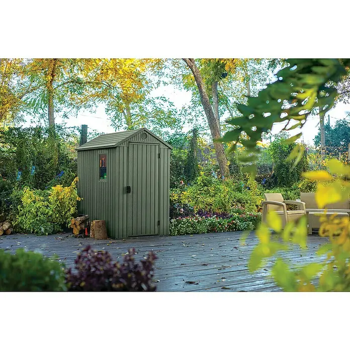 Keter Gerätehaus Darwin 4x6 - Außenmaß inkl. Dachüberstand (B x T): 125,8 x 184,5 cm, Kunststoff, Grün - Geräumiger grauer Gartenschuppen auf einer Holzterrasse, umgeben von üppigem Grün und Bäumen, ideal zur Aufbewahrung von Gartengeräten.