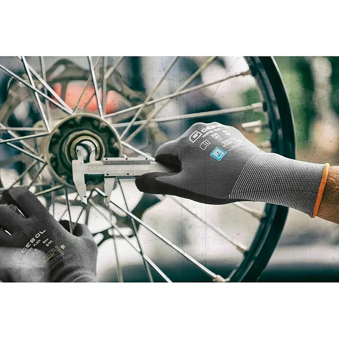Gebol Guantes de trabajo Master Flex - Talla del guante: 8, Gris - Primer plano de guantes de trabajo CEGOL midiendo el buje de una bicicleta con un calibrador. Ideal para trabajos precisos.