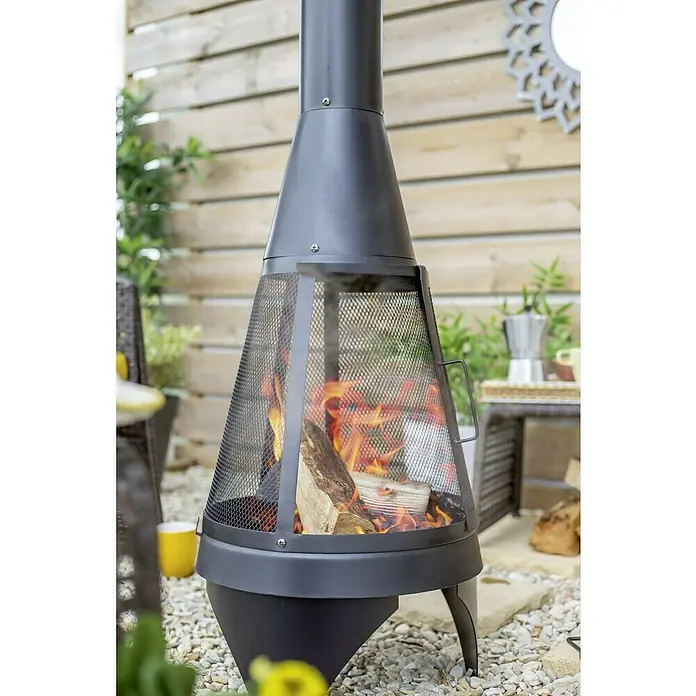 Buschbeck Chimenea para jardín Colorado Mesh - L x An x Al: 60 x 60 x 160 cm, Acero - Chimenea negra con malla metálica y leña ardiendo, ideal para añadir calidez y ambiente al jardín.