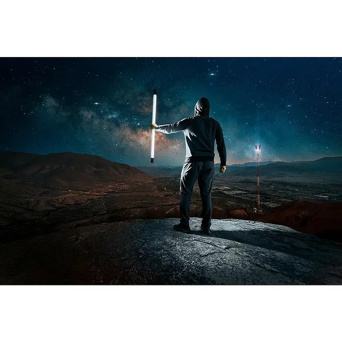 Osram LED-Röhre Tube T8 36 EM Ultra - Länge: 121,3 cm, Tageslichtweiß, 20 W, 2.400 lm, G13 - Mann mit leuchtendem Stab auf einem Felsen vor Sternenhimmel und Antenne. Futuristische Szene in mystischer Nachtlandschaft.