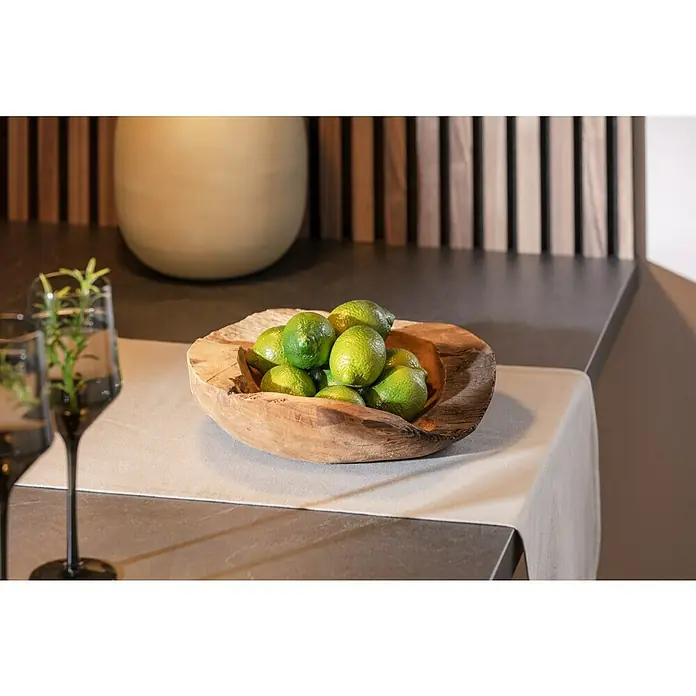 Teakschale Natur - Durchmesser: 30 cm, Teak, Rund - Eine rustikale Holzschale gefüllt mit frischen Limetten, platziert auf einem beigen Tischläufer neben zwei eleganten Gläsern.