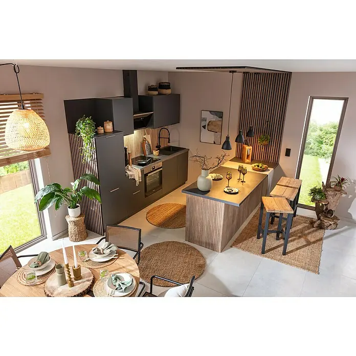SCHÖNER WOHNEN-Farbe Wandfarbe Designfarbe - Weiches Strandbeige, Matt, 2,5 l, Konservierungsmittelfrei - Helle und moderne Küche mit dunklen Schränken, einer Kücheninsel mit Barhockern und einem Esstisch mit Stühlen. Die Küche ist mit Pflanzen dekoriert.