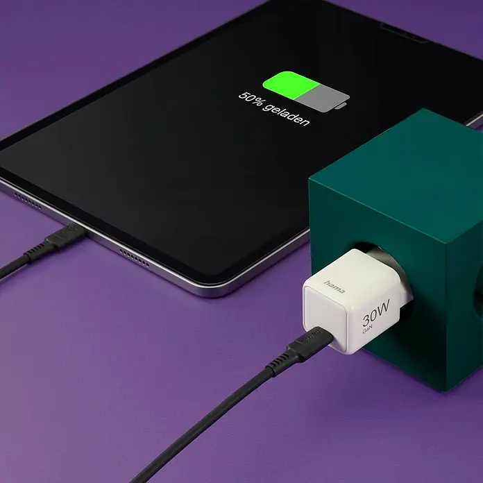 Hama USB-Adapter Schnellladegerät - 30 W, Weiß, USB C-Stecker - Ein Hama 30W GaN-Ladegerät steckt in einer Steckdosenleiste, ein Tablet wird damit geladen, der Akkustand beträgt 50 %.