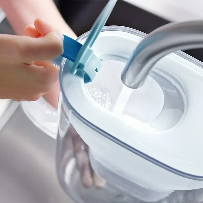 Brita Jarra filtrante Maxtra Pro - Capacidad volumétrica: 2,4 l, 1 ud., Transparente/Azul - Una jarra de filtro de agua se llena con agua debajo de un grifo, la jarra es azul claro y transparente.