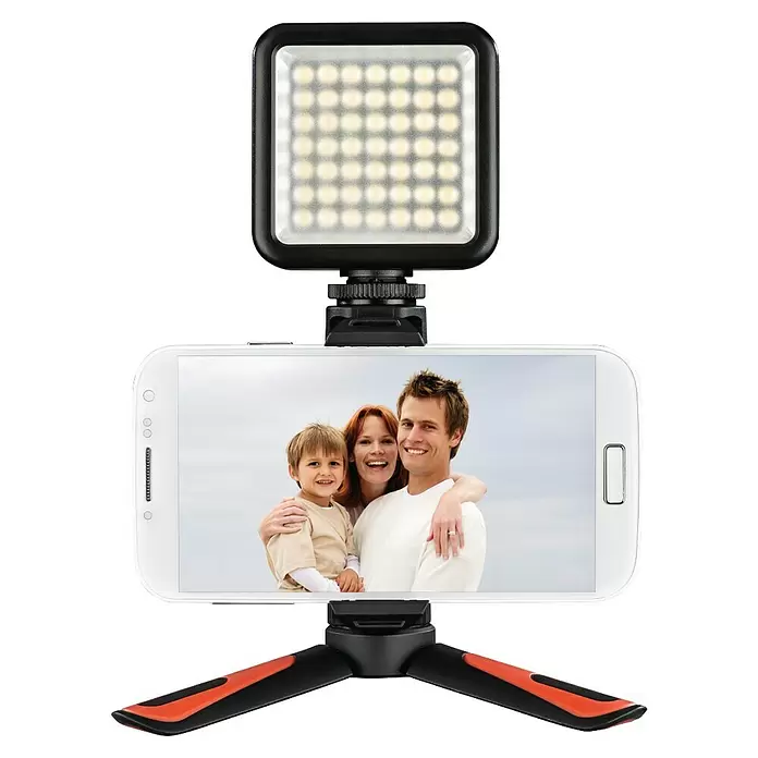 Hama Smartphone-Halter Mini-Stativ "Pocket II Rotation" 15 cm - Schwarz, Rot - Schwarze quadratische LED-Leuchte auf weißem Smartphone mit Familienfoto, montiert auf schwarzem und orangem Ministativ.