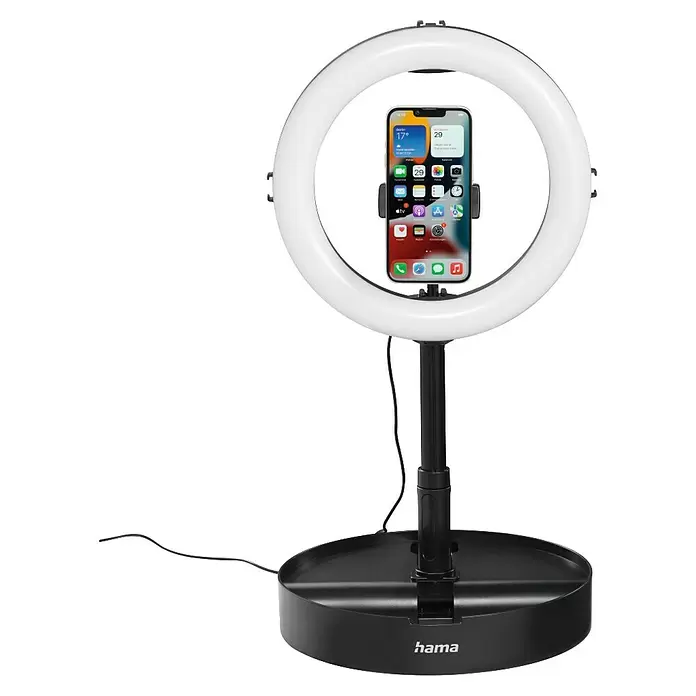 Hama Smartphone-Halter LED-Ringleuchte "SpotLight FoldUp 102 II" - Schwarz - Schwarze Ringleuchte mit weißem LED-Ring und integriertem Smartphone-Halter, ein iPhone haltend. Die Basis trägt das Hama-Logo.
