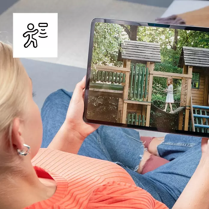 Hama Wifi Überwachungskamera - Weiß, Erfassungswinkel: 110 ° - Frau überwacht Kind auf Spielplatz per Tablet, mit Personenerkennungs-Symbol.