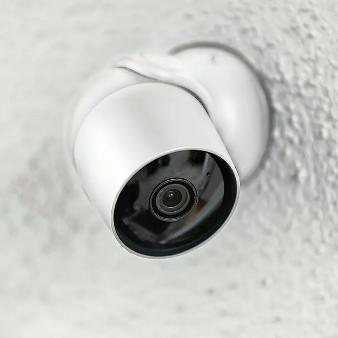 Hama Wifi Überwachungskamera 176645 - Erfassungswinkel: 110 ° - Nahaufnahme einer weißen Überwachungskamera, die an einer Wand befestigt ist und ein Gefühl von Sicherheit vermittelt.