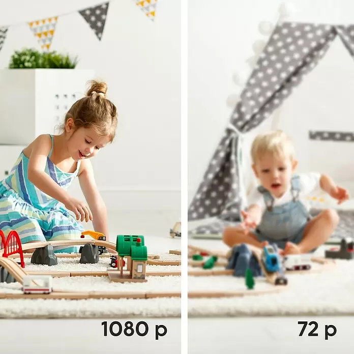 Hama Wifi Überwachungskamera - Erfassungswinkel: 100 ° - Zwei Kinder spielen mit Holzeisenbahn-Sets. Die Sets umfassen Gleise, Brücken und kleine Gebäude für fantasievolles Spielen.
