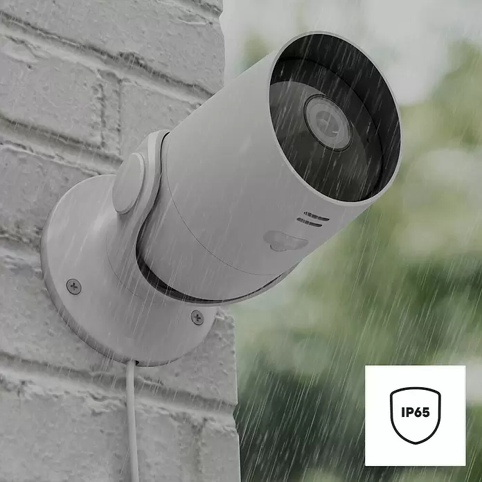 Hama Wifi Überwachungskamera 176645 - Erfassungswinkel: 110 ° - Weiße Outdoor-Überwachungskamera an einer Ziegelwand im Regen, mit IP65 Wetterschutz.