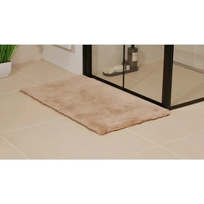 Badteppich Happy - 50 x 90 cm, Taupe, 100% Polyester - Weicher, beigefarbener Badteppich vor einer Duschkabine auf hellen Badezimmerfliesen, der Komfort und Stil vereint.