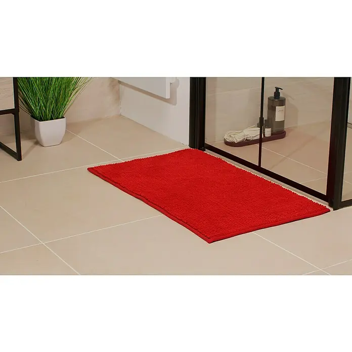 Camargue Badteppich Zottel50 x 80 cm, Rot, 100% Polyester - Ein roter Badteppich liegt vor einer Duschkabine, neben einem grünen Pflanzentopf und sorgt für einen Farbakzent im Badezimmer.