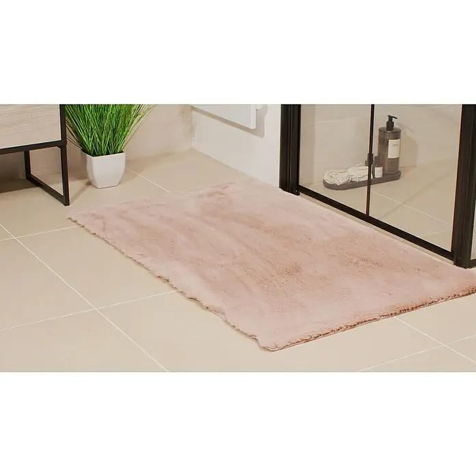 Badteppich Happy - 67 x 110 cm, Rosa, 100% Polyester - Nahaufnahme eines rosafarbenen Teppichs im Badezimmer, der eine weiche und einladende Atmosphäre schafft.