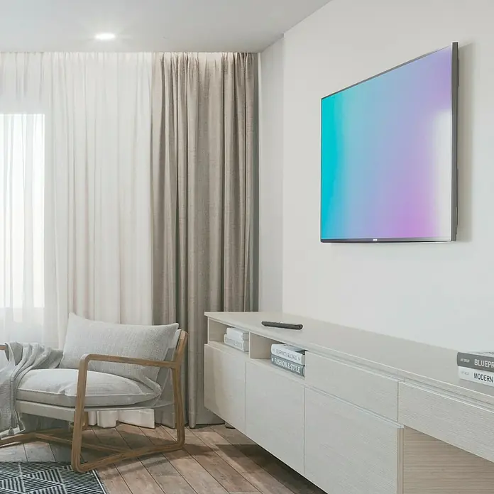 Hama TV-Wandhalterung starr - Passend für: Bildschirmgröße: 94 - 229 cm (37" - 90") bis 100 kg - Ein stilvolles Wohnzimmer mit einem modernen Fernseher an der Wand und einem bequemen Sessel. Die Einrichtung ist hell und einladend gestaltet.