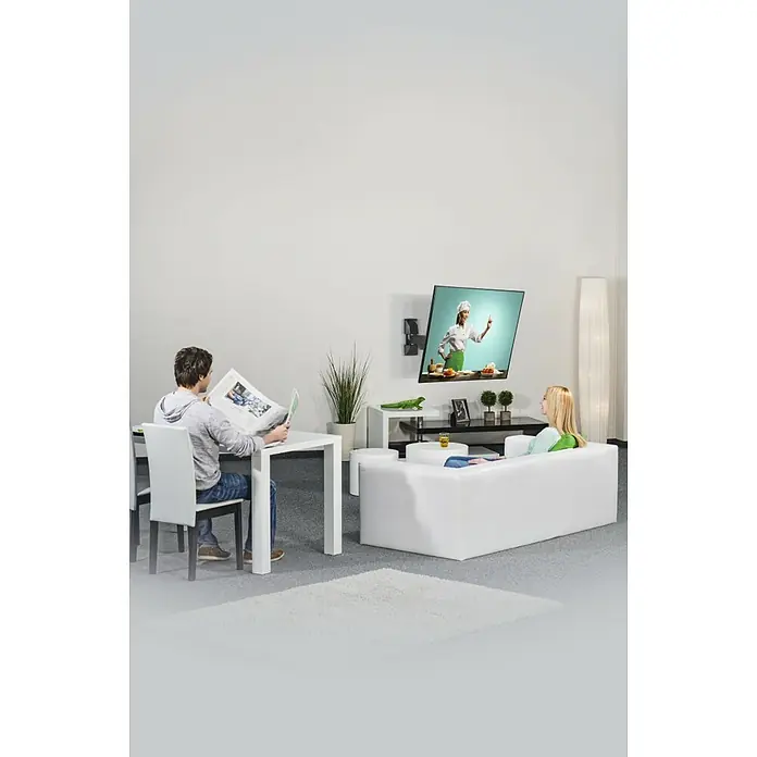 Hama TV-Wandhalterung schwenkbar, neigbar - Passend für: Bildschirmgröße: 81 - 165 cm (32"- 65") bis 20 kg - Das Bild zeigt eine moderne TV-Wandhalterung in einem hellen Wohnzimmer, während eine Frau fernsieht und ein Mann Zeitung liest.