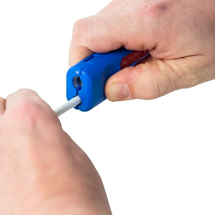 Weicon Kabelentmanteler Coax-Stripper No. 1 F Plus - Blau, Rot, Passend für: Koaxialkabel, bzw. Antennen- und Übertragungskabel - Koaxialkabel-Abisolierwerkzeug "No. 1 F Plus" im Einsatz, um ein Kabel vor schwarzem Hintergrund abzumanteln.