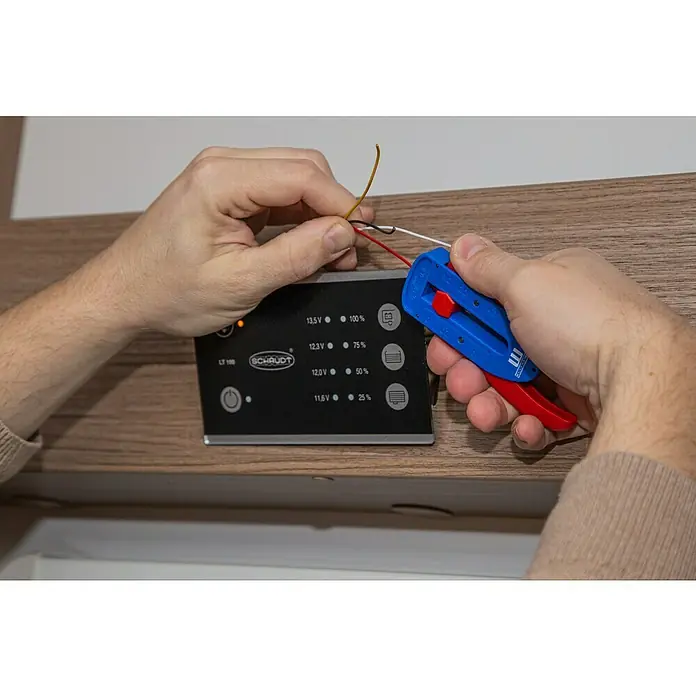 Weicon Kabelentmanteler Präzisions-Abisolierer S - Passend für: Feindrähtige Leiter und Litzen, PVC-, PTFE/Teflon-, Kynar-Isolationen von 0,12 mm - 0,8 mm - Ein Elektriker benutzt einen Abisolierer, um die Enden von Kabeln freizulegen, die mit einer schwarzen Schaudt-Steuerung verbunden werden sollen.