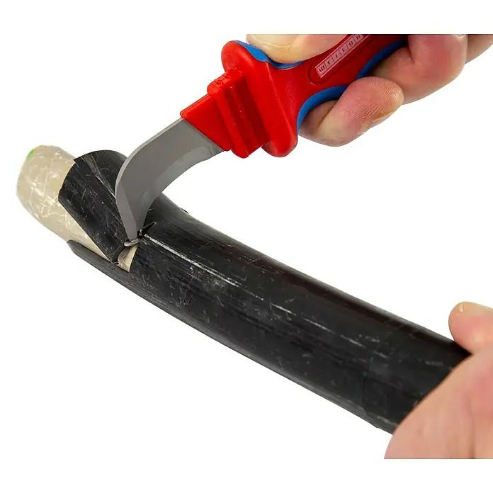 Weicon Kabelmesser H.D. No. 1000 - Blau, Rot, Passend für: Mehrfach isolierte und dicke Kabel mit PVC-Isolationen - Nahaufnahme eines KNIPEX ErgoStrip Universal-Abmantelungswerkzeugs beim Abisolieren eines Kabels. Das Werkzeug hat einen roten Griff und eine gebogene Klinge.