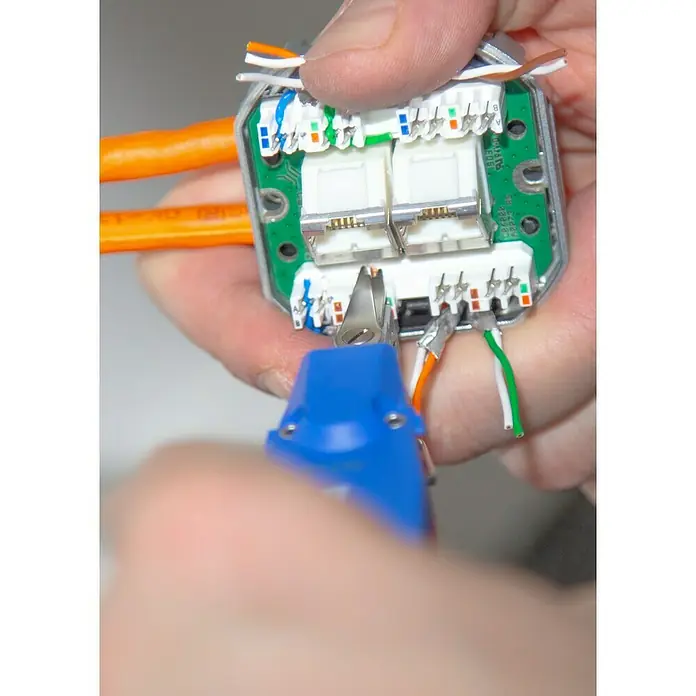 Weicon Anlegewerkzeug LSA Sensor No. 40 - Blau, Rot, Passend für: Beschaltung LSA-Baureihe - Ein Elektriker verwendet ein Anlegewerkzeug, um farbcodierte Netzwerkwerkkabel in einen Netzwerkanschluss zu stanzen.