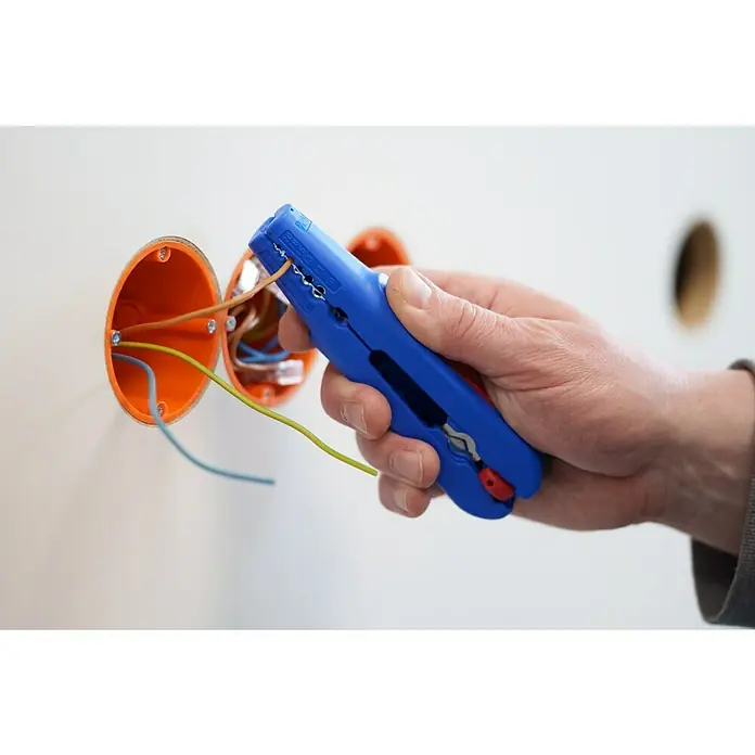 Weicon Kabelentmanteler Multi-Stripper No. 400 - 0,5 mm² - 6 mm², Blau, Rot - Abisolierzange im Einsatz zum Abisolieren von Kabeln in einer Installationsdose.